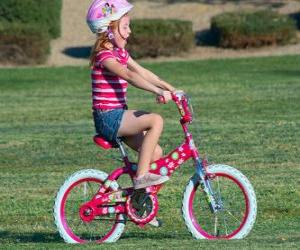 Rompicapo di Ragazza in bicicletta nel parco in primavera