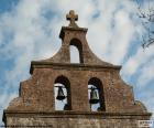 Campanile di una chiesa con due campane e una croce in alto a sinistra