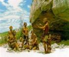 Gruppo di uomini di Neandertal sotto la protezione di un riparo roccioso, le persone che svolgono attività diverse: alcuni carving pietre, altri preparano a caccia