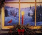 Candela accesa di Natale di fronte a una finestra