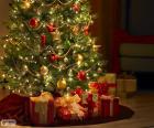 Albero di Natale decorato con perle, nastri, una grande stella e con doni sotto