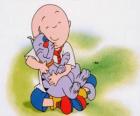 Caillou seduto sul pavimento e abbracciando il suo gatto Gilbert