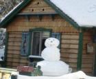 Pupazzo di neve vicino ad una casa