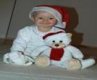 Ragazzo con un cappello di Babbo Natale con il suo orsacchiotto