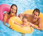 Giovane coppia con la figlia in piscina