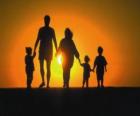 Famiglia, padre, madre e figli a piedi a tre crepuscolo