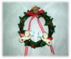 Ghirlanda di Natale decorato con foglie di agrifoglio una testa di una renna, due angeli e un fiocco rosso
