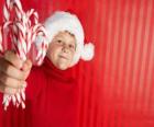Bambino con cappello di Babbo Natale e le caramelle in mano