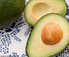 Avocado, frutto intero partito e la frutta a metà con semente