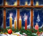 candele di Natale illuminata davanti ad una finestra