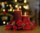 candele accese come centrotavola decorato con fiori di Natale
