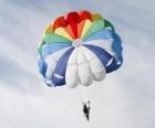 Paracadutista giù attraverso le nubi di un paracadute dopo il salto da un aereo