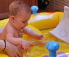 Ragazza di balneazione in una piccola piscina gonfiabile