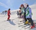 Gruppo di bambini attenti all'istruttore di sci