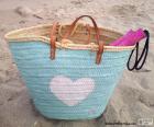 Borsa blu e un cuore bianco, con gli utensili per la spiaggia