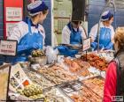 Tre pescatrici lavorano nel pescheria del supermercato