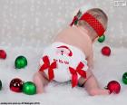 Un bambino molto Natale, con un pannolino di Babbo Natale e le varie palle colorate
