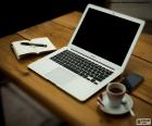 Tavolo di lavoro con un MacBook Air, un computer portatile molto sottile e leggero