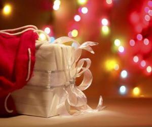 Rompicapo di Regalo di Natale avvolto in carta bianca e decorato con un arco